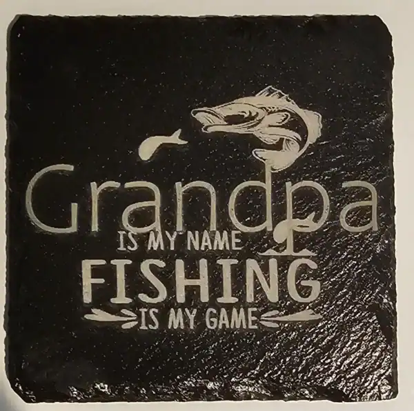 Slate coaster engraved with "Grandpa is my name, fishing is my game" and a fish illustration.