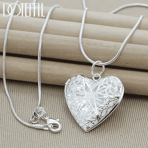 Elegant silver heart necklace with intricate cut-out leaf and floral design.