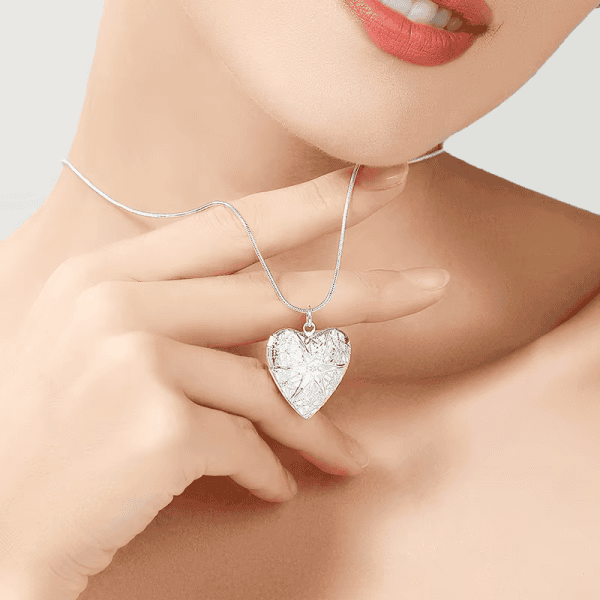 Delicate silver heart pendant necklace with intricate laser engraving, perfect for elegant jewelry gifts.