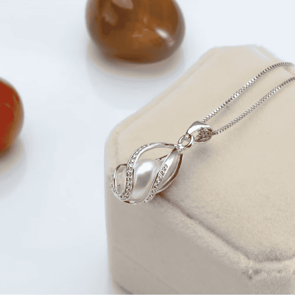 Delicate silver necklace featuring a pearl pendant with sparkling crystals, perfect for jewelry lovers.